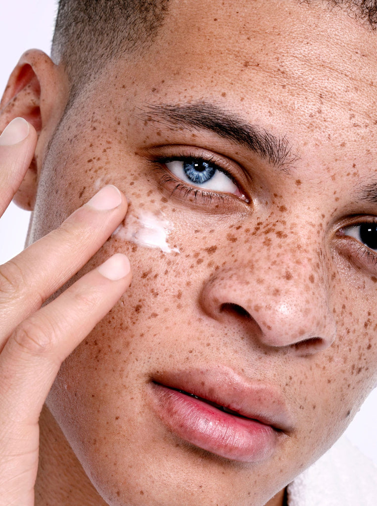 Male model with freckles applying 王者信用结果查看网官方 PROUD Bright Eye cream
